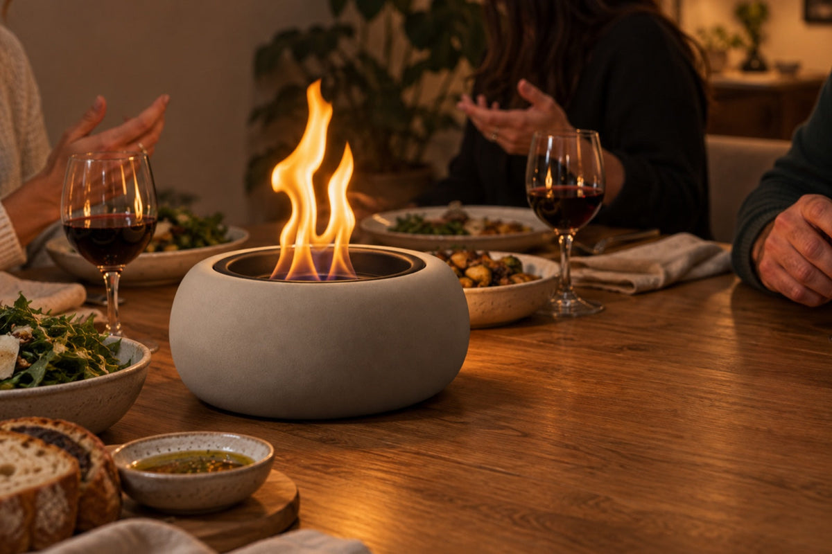 Bioethanol tabletop fire bowl burning on a dining table during an indoor dinner